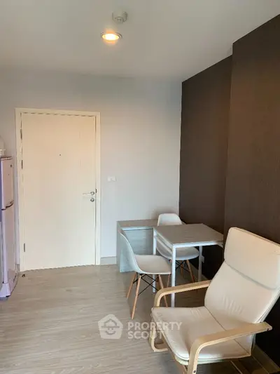 Modern minimalist studio apartment with sleek white furniture and contrasting dark accent wall, perfect for urban living.