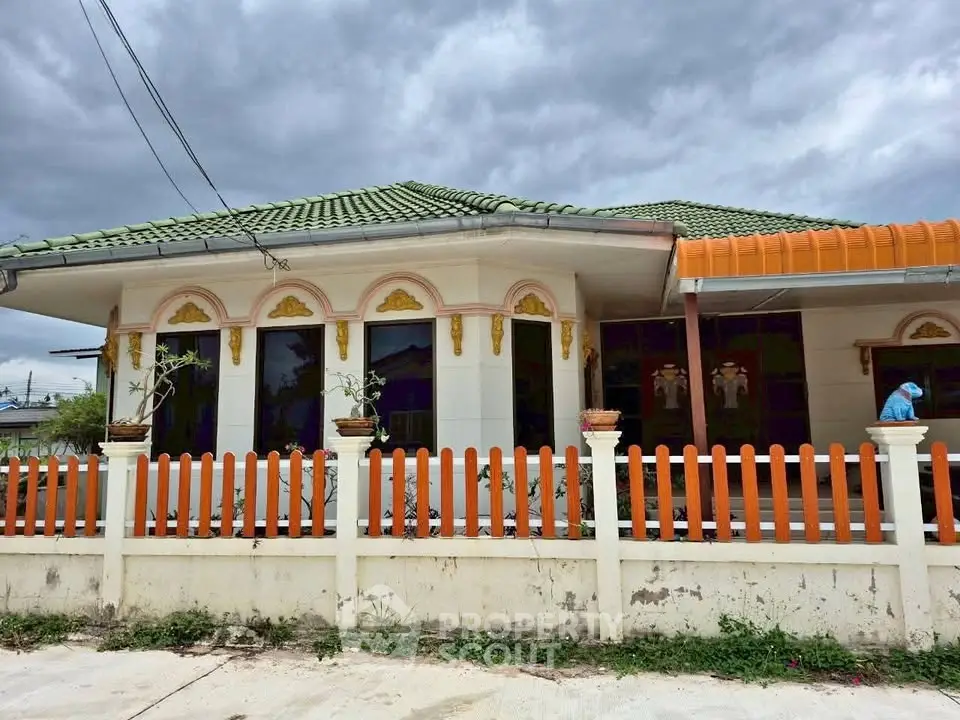 Charming single-story home with unique architectural details and vibrant orange accents.