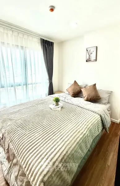 Bright and cozy bedroom with large window and stylish decor
