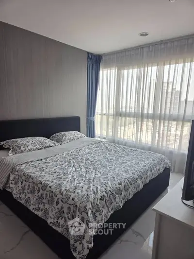 Modern bedroom with large window and stylish decor in a high-rise apartment.