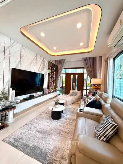 Luxurious living room with modern decor, large TV, and elegant lighting in a stylish home.