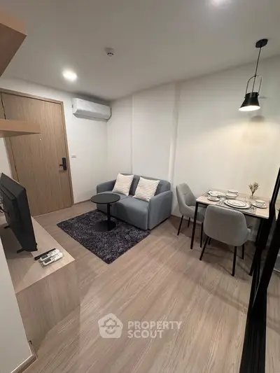 Modern living room with cozy seating and dining area in a stylish apartment.