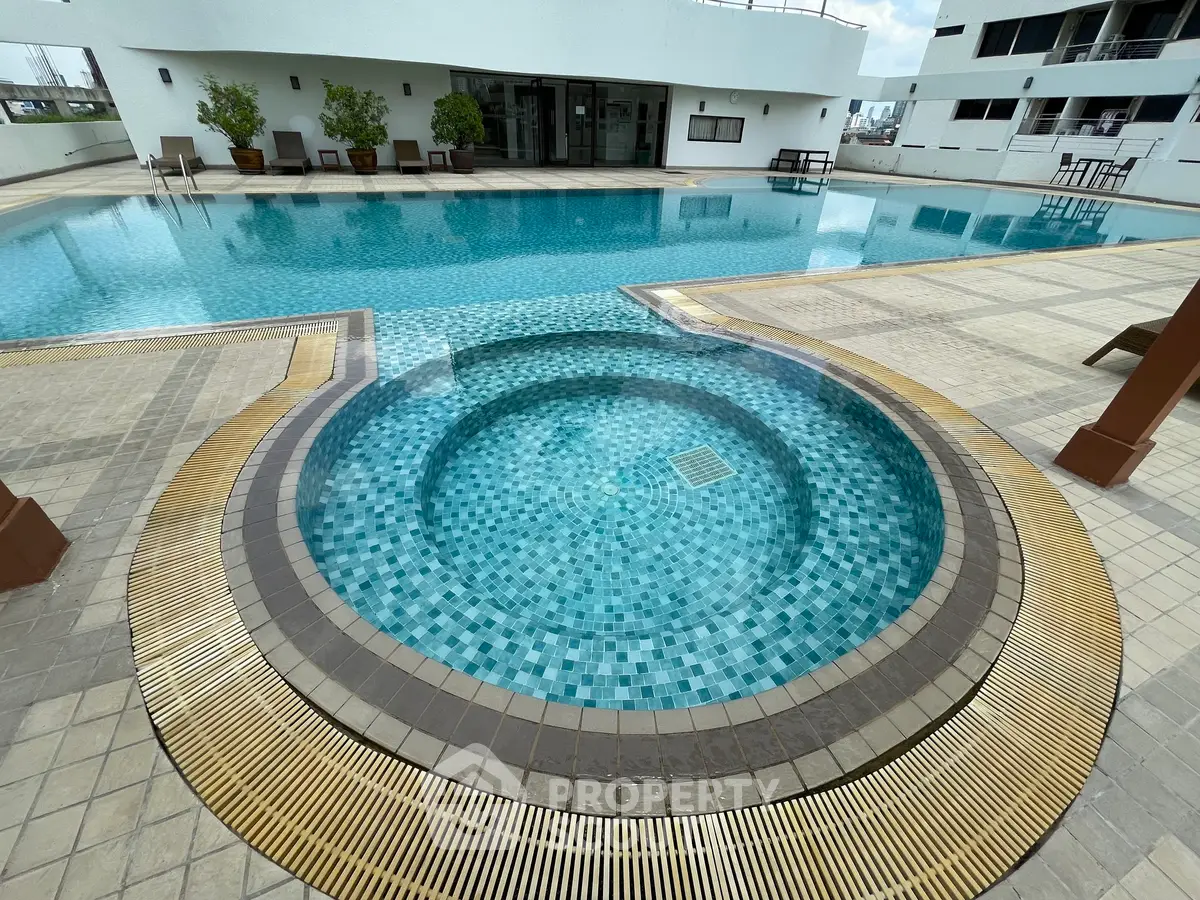Luxurious rooftop pool with jacuzzi offering stunning city views and relaxation area.