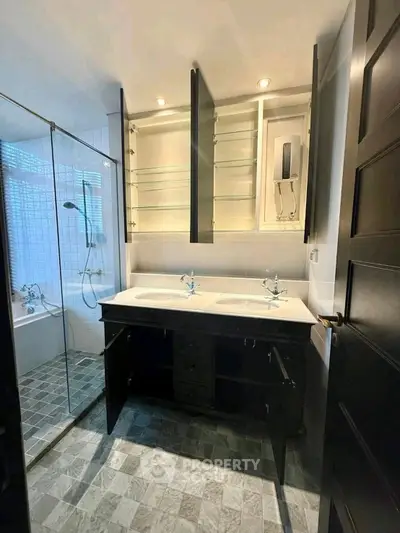 Modern bathroom with dual sinks and glass shower enclosure