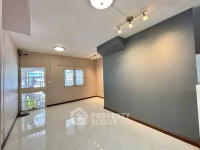 Spacious living room with modern lighting and tiled flooring