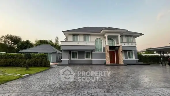 Elegant two-story house with spacious driveway and lush greenery, perfect for luxurious living.