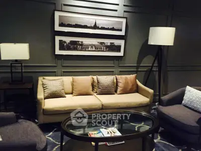 Elegant living room with stylish sofa, modern lamps, and framed artwork on paneled wall.