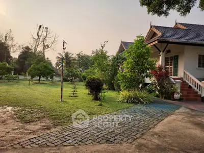 Charming suburban home with lush garden and paved walkway, perfect for nature lovers seeking tranquility.