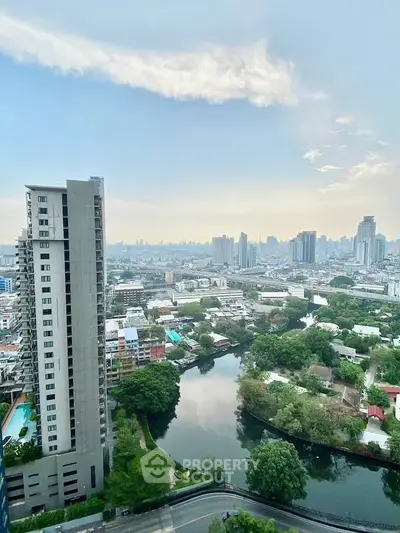 Stunning cityscape view from high-rise apartment overlooking river and skyline.