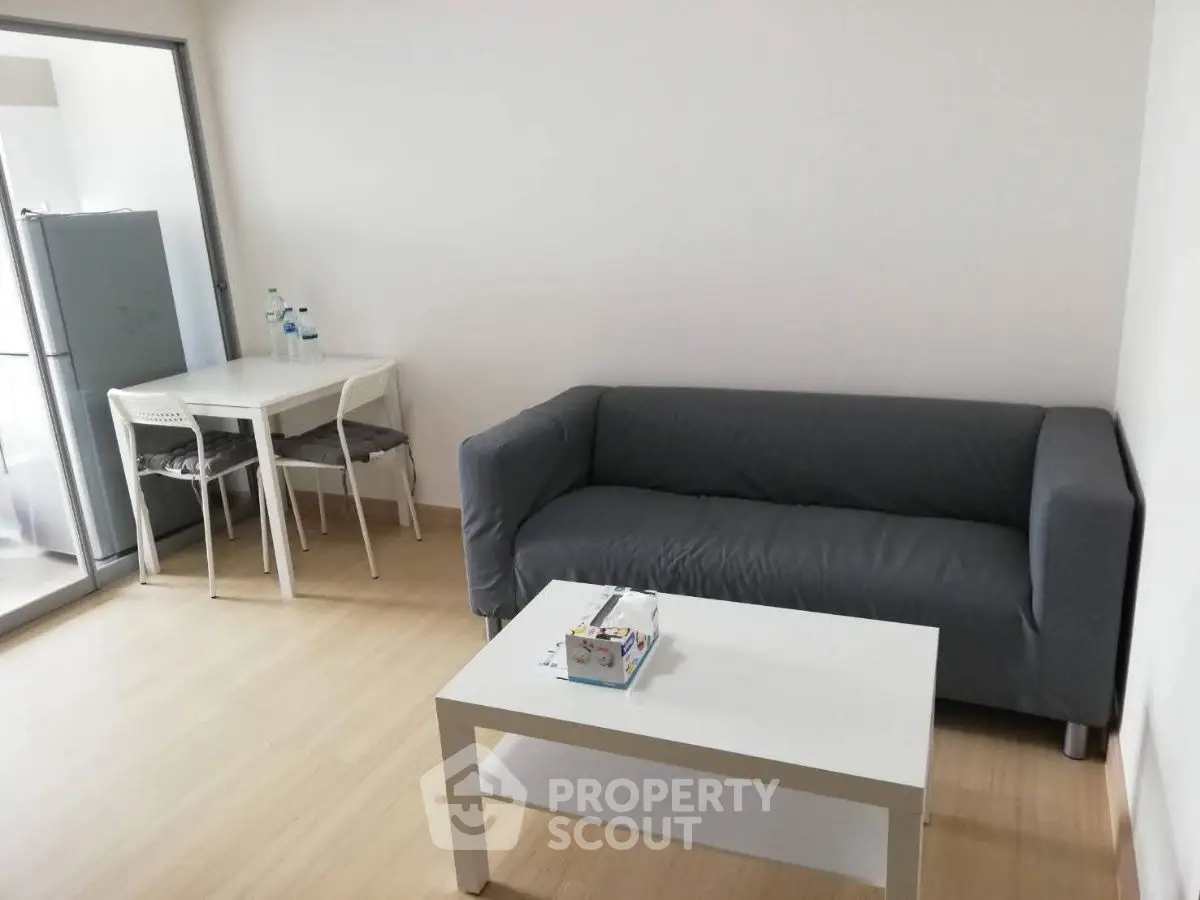 Cozy living room with gray sofa and modern dining area in open layout.