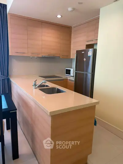 Modern kitchen with sleek cabinetry and stainless steel appliances in a stylish apartment.
