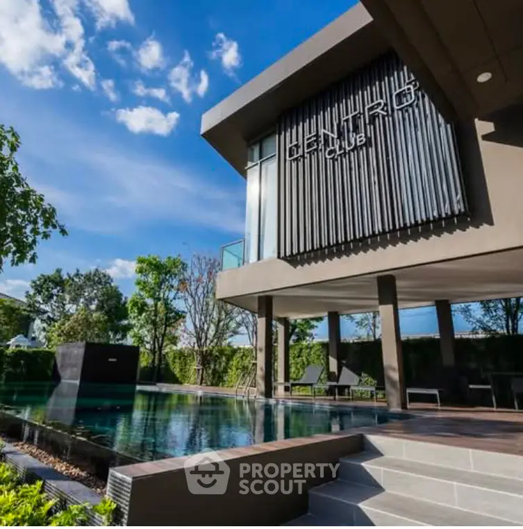Luxurious modern building with pool and lush greenery, perfect for relaxation and leisure.