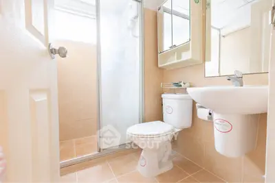 Bright and clean bathroom with modern fixtures and a glass shower enclosure.