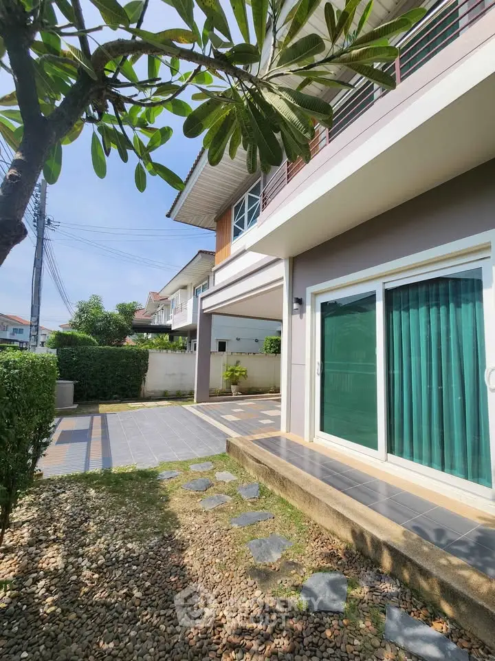 Charming modern house exterior with lush garden and spacious patio area.
