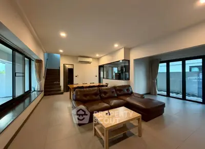 Spacious modern living room with leather sofa and large windows