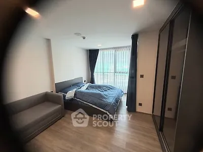 Modern bedroom with large window and stylish furnishings in a contemporary apartment.