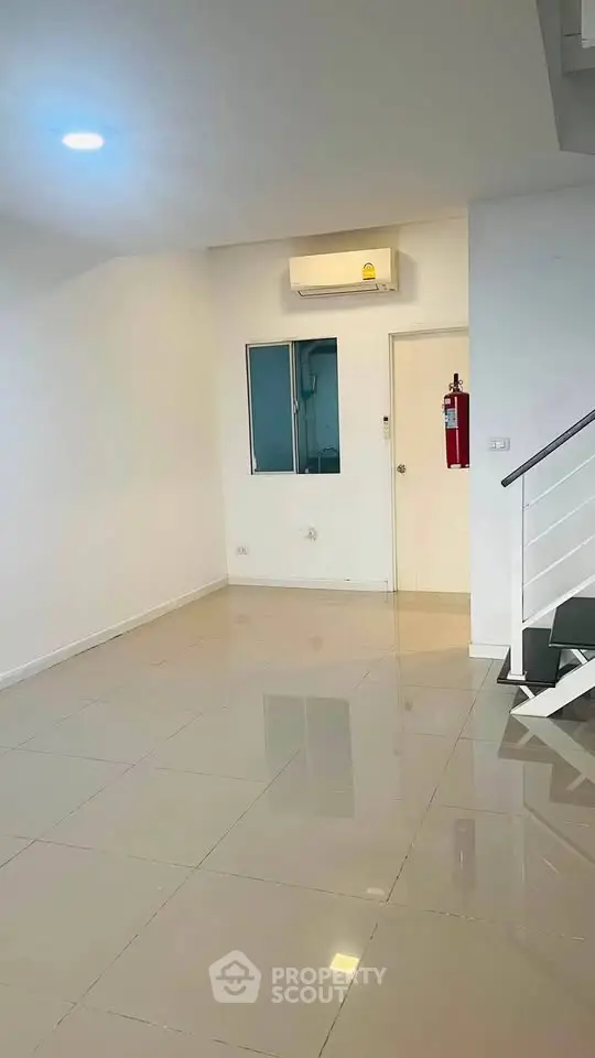 Spacious modern living room with sleek tile flooring and air conditioning unit.