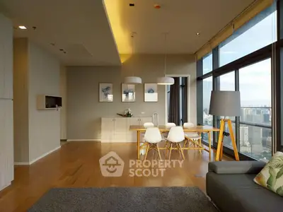Spacious modern living room with dining area and city view, featuring elegant decor and natural light.