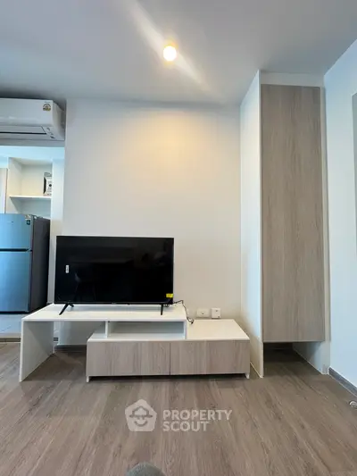 Modern living room with sleek TV stand and air conditioning unit, featuring minimalist design and wooden flooring.