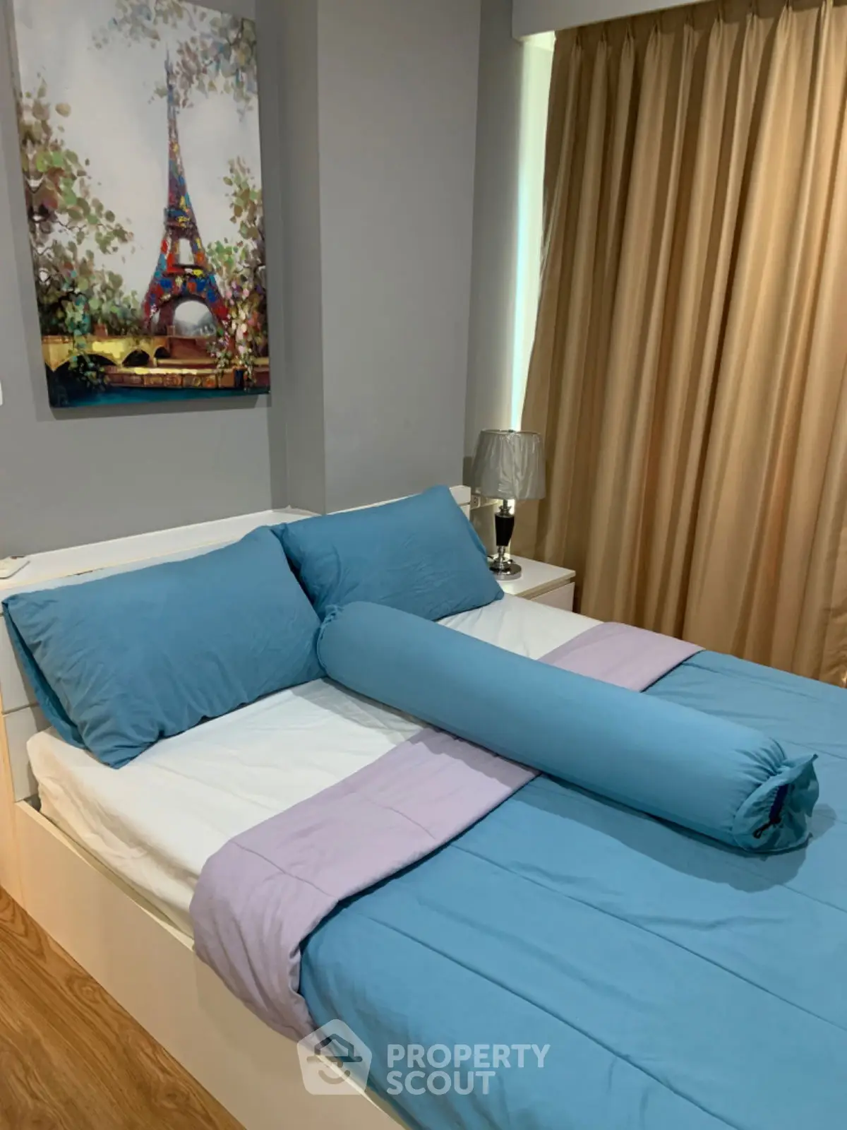 Cozy bedroom with modern decor and vibrant blue bedding, perfect for relaxation.