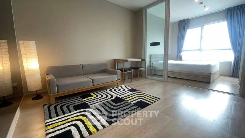 Modern living room with stylish decor and cozy bedroom view in open layout apartment.