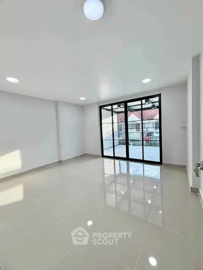 Spacious empty room with large windows and balcony access, perfect for customization.