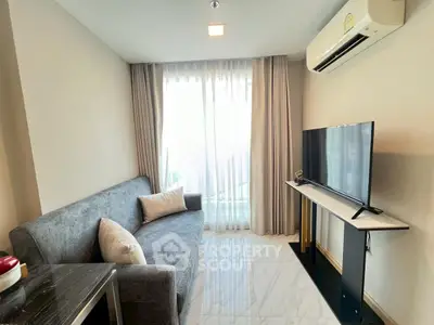 Modern living room with sleek furniture and natural light, featuring a cozy sofa and flat-screen TV.