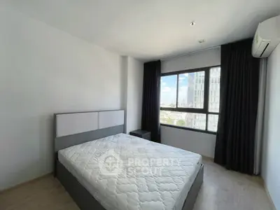 Spacious bedroom with large window offering city views, featuring a modern bed and air conditioning.