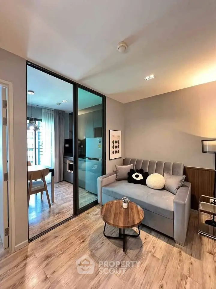 Modern living room with sleek design and open kitchen layout in a stylish apartment.
