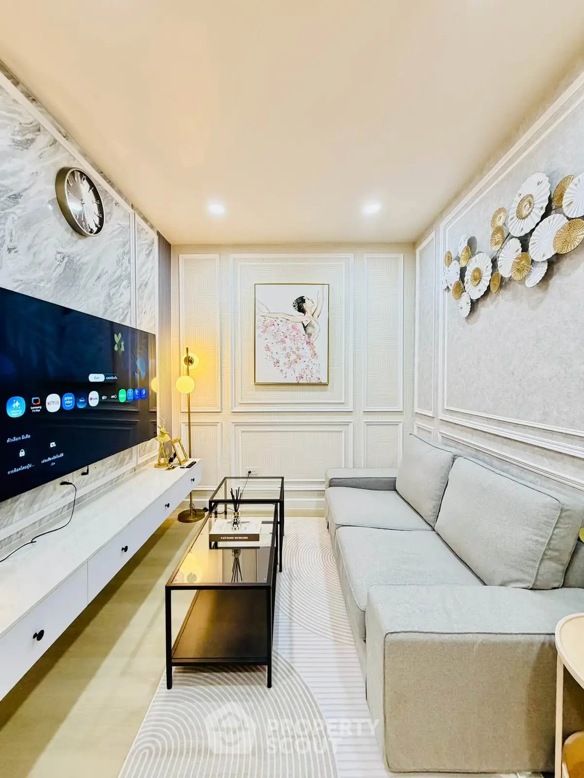 Elegant living room with modern decor, large TV, and stylish furniture in a cozy setting.