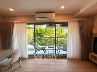 Modern living room with balcony view and stylish furniture in a bright apartment.