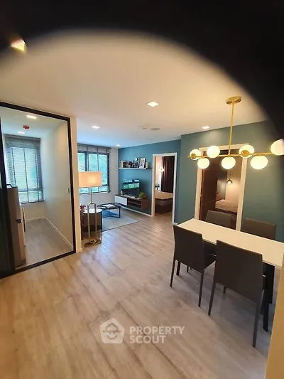 Modern open-plan living and dining area with stylish lighting and cozy decor