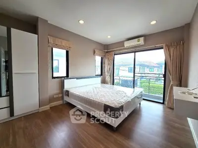 Spacious bedroom with large windows and modern furnishings