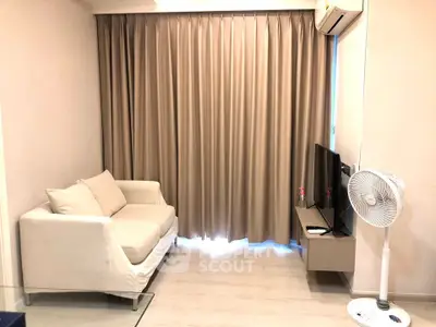 Cozy living room with modern sofa, TV, and air conditioning, perfect for relaxation.