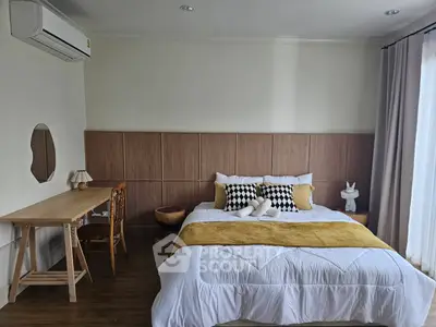 Cozy bedroom with stylish decor and natural light, featuring a comfortable bed and elegant wooden desk.