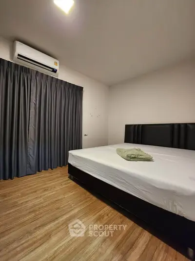 Spacious bedroom with modern design, featuring a comfortable bed and elegant flooring.