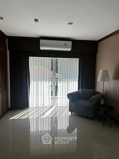 Spacious living room with modern decor and large window for natural light.