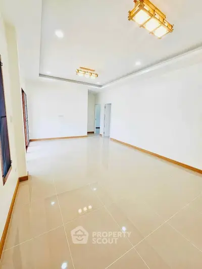 Spacious and bright living room with modern lighting and glossy tiled flooring.