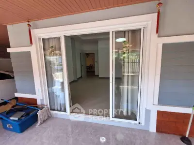 Charming home entrance with sliding glass doors and inviting interior view.