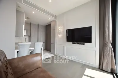 Modern living room with sleek TV setup and elegant kitchen area