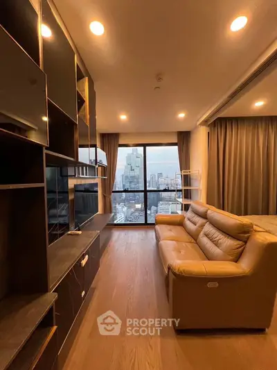 Modern living room with city view, featuring sleek shelving and comfortable leather sofa.