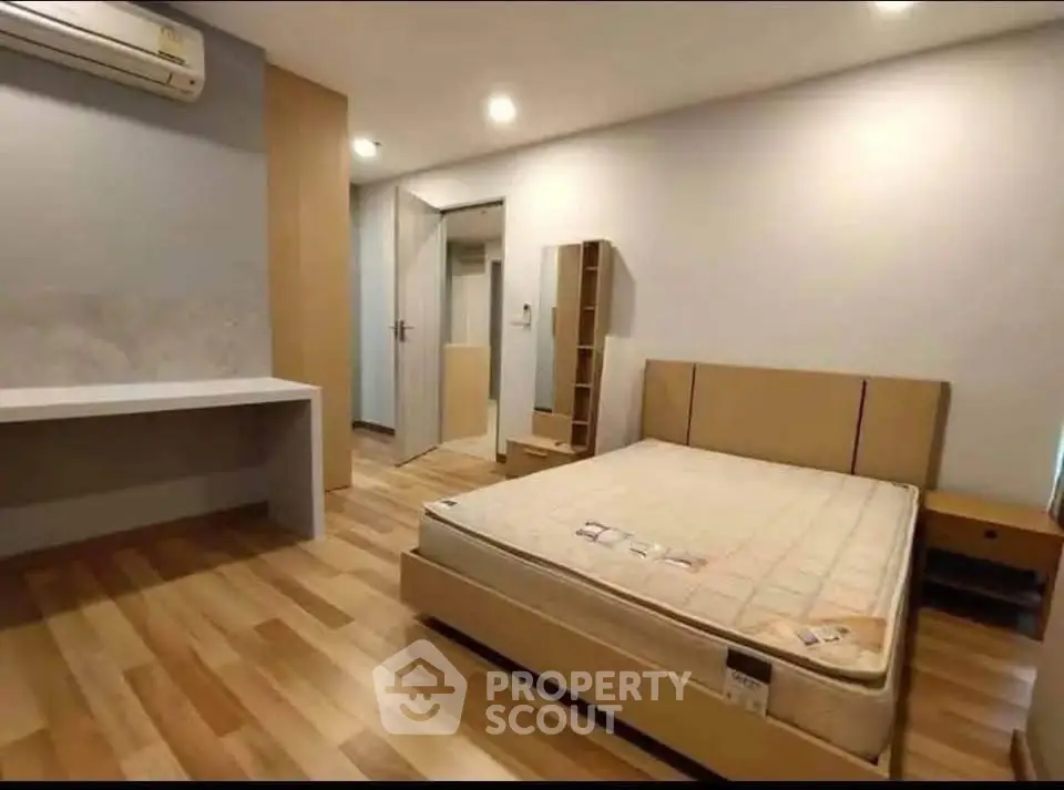 Spacious bedroom with modern furnishings and wooden flooring, ideal for comfort and relaxation.