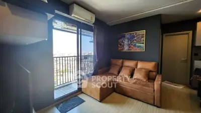 Modern living room with balcony view and stylish brown sofa in urban apartment.