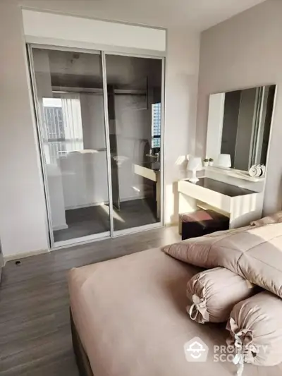 Modern bedroom with stylish decor and mirrored closet doors in a high-rise apartment.