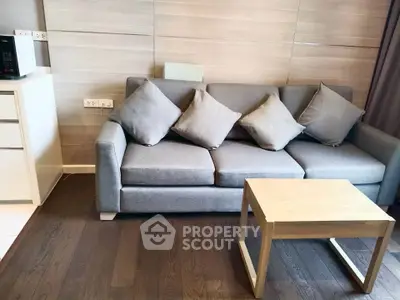 Modern living room with stylish gray sofa and wooden coffee table on elegant hardwood floor.