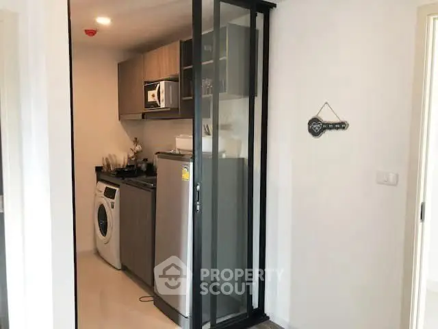 Modern compact kitchen with washing machine and stainless steel fridge