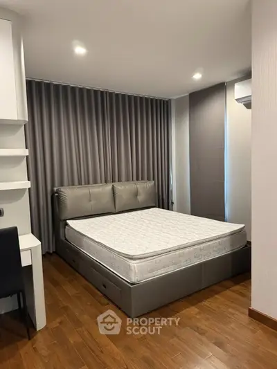 Modern bedroom with sleek design, featuring a comfortable bed, wooden flooring, and stylish curtains.