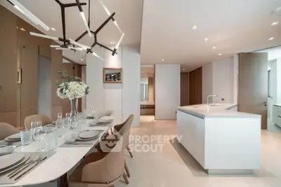 Luxurious open-plan kitchen and dining area with modern lighting and elegant decor.
