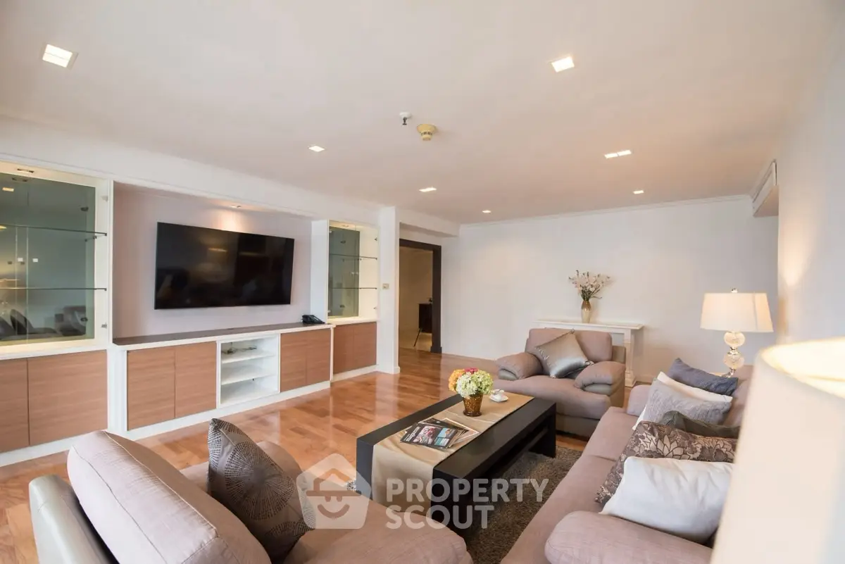 Spacious living room with modern decor and large TV, perfect for relaxation.