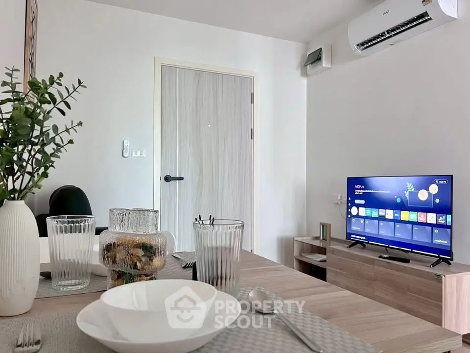 Modern living room with stylish decor, air conditioning, and smart TV setup.